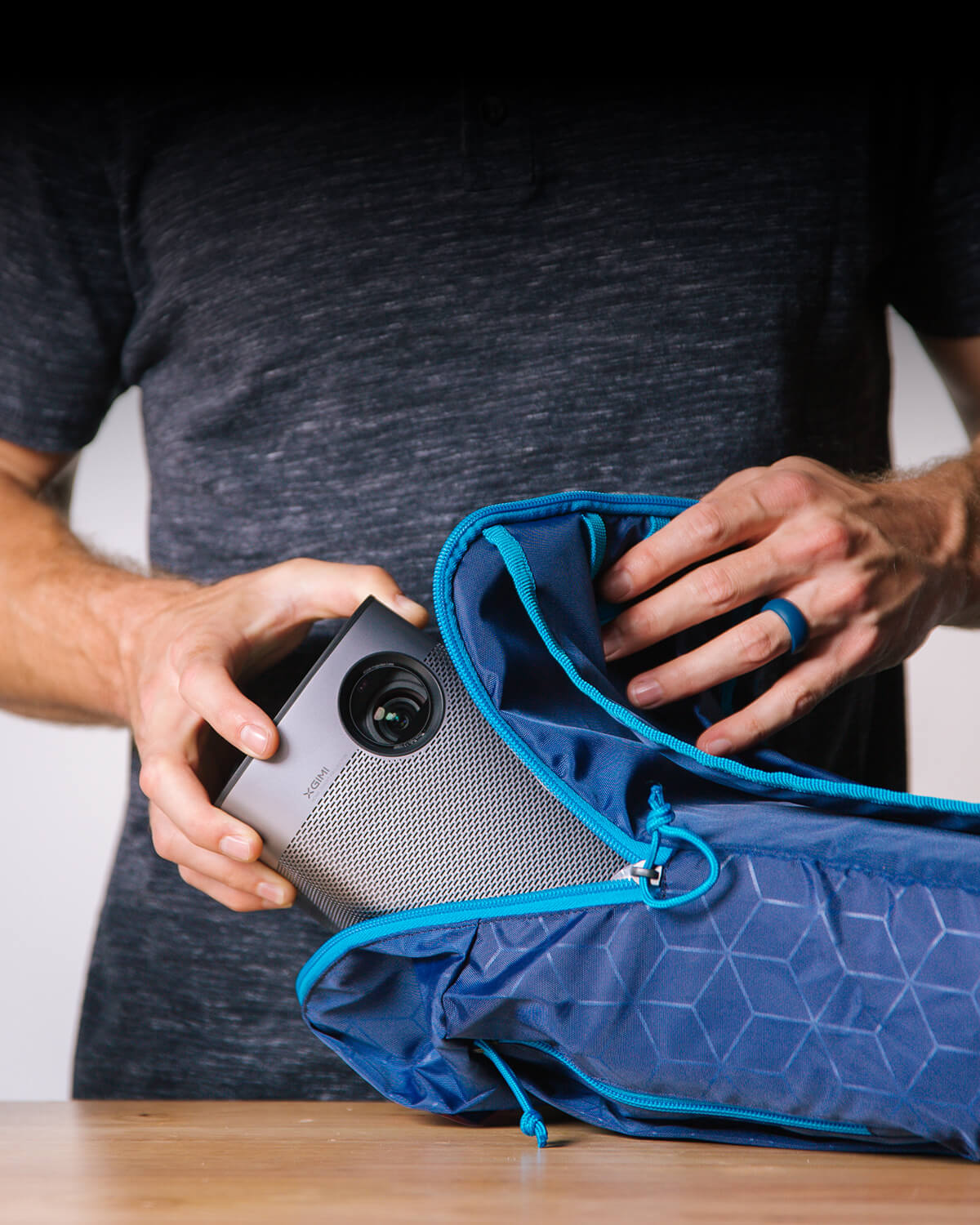 User packing the ultra-portable Halo+ (New) projector with 59Wh battery for outdoor adventure