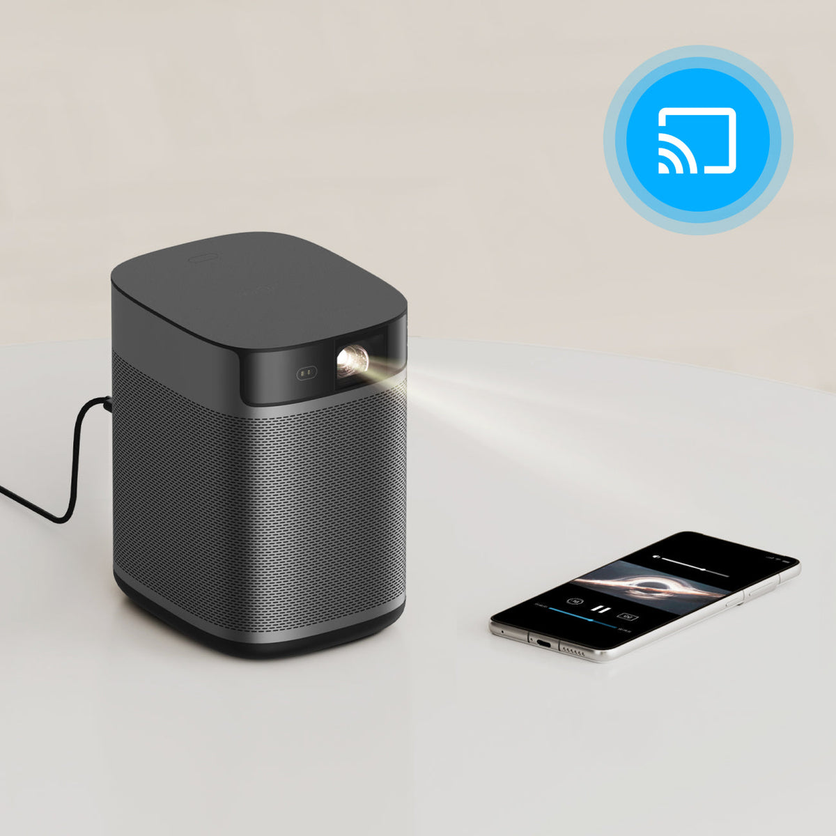 A portable black smart projector with a light beam, shown next to a smartphone with a wireless casting icon.